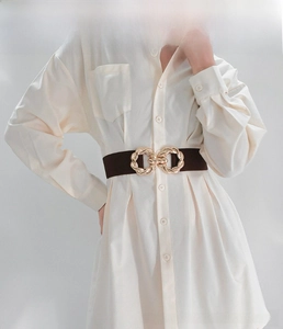 Detailed view of wide dark brown elastic waist belt with a golden twist metal buckle