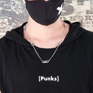 Close-up of a silver spring-link necklace worn by a model in a street style punk setting
