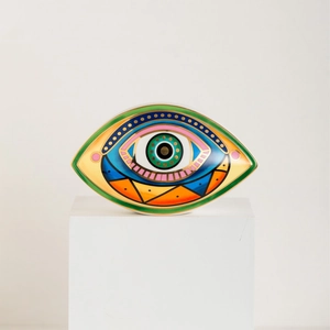 Adorno de cerámica Ojo de la Suerte con patrones geométricos coloridos en pedestal blanco