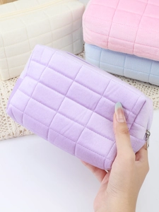 Close-up of quilted velvet makeup bags in pastel purple, pink, blue and beige colors