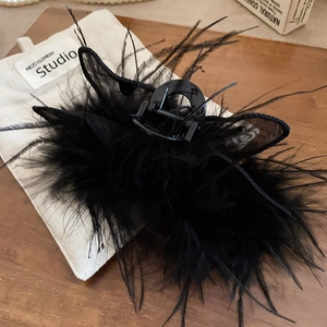 Close-up of black feather rabbit ear hair claw clip with delicate mesh on white bag