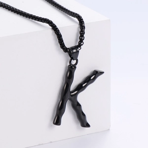 Vue détaillée du pendentif lettre K noir avec texture de bambou unique en relief