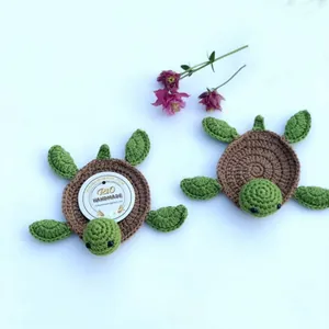 Detailed top view of two handmade crochet turtle coasters with textured brown shells