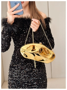 Detail of a golden irregular stone-shaped mirror clutch bag with a sleek metal chain strap