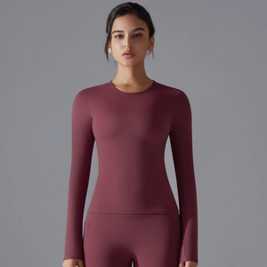 Detail of burgundy long sleeve yoga top featuring slim fit design and crew neck line