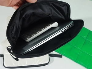 Macro shot of black puffy laptop sleeve interior showing spacious quilted storage