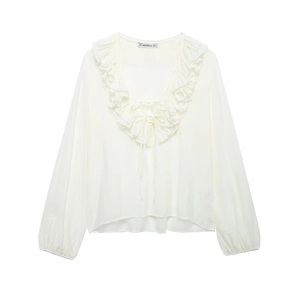 Close-up of white chiffon shirt featuring V-neckline with ruffle details and neck ties