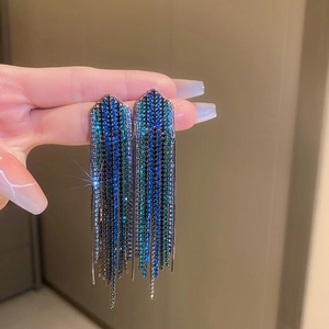 Macro shot of long tassel earrings with blue and green gradient rhinestones detail
