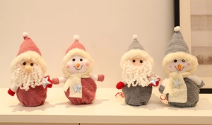 Détail de figurines de Noël en tricot rose et gris dans un décor intérieur chaleureux