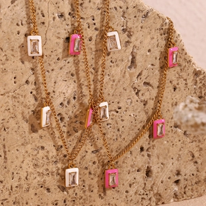 Detail of gold-plated rectangular pendants with pink and white enamel and zircons