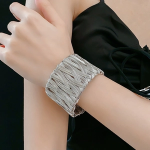 Close-up of a silver twisted weave cuff bracelet on a wrist with minimalist design