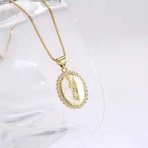Detail of gold oval religious pendant with white mother-of-pearl inlay and micro-zirconia