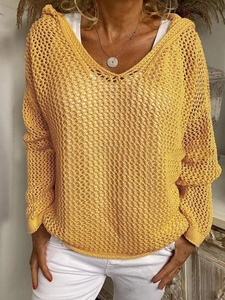 Nahaufnahme der ingwergelben Strickstruktur und Kapuzendetails am lockeren Pullover