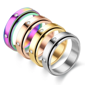 Detail of four colorful rotating stainless steel spinner rings with small zircon stones