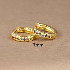 Detailed view of 7mm 18K gold huggie earrings with colorful inlaid rainbow zircons