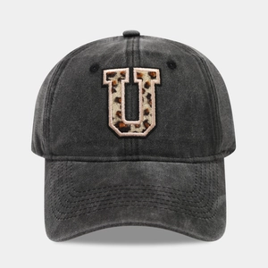 Detail of washed black baseball cap with leopard print letter U patch and pink stitching