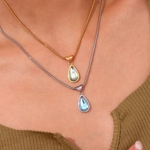 Double layered gold and silver waterdrop pendant necklace featuring green and blue gemstones