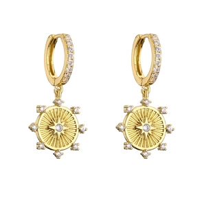 Detail of gold huggie earrings with sparkling starburst charms and micro-pave zircons