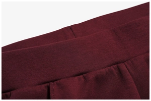 Detail shot of the elastic waistband stitching on the dark red knitted outdoor sweater