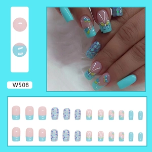 Detail of teal butterfly press-on nails set with glitter accents and French design