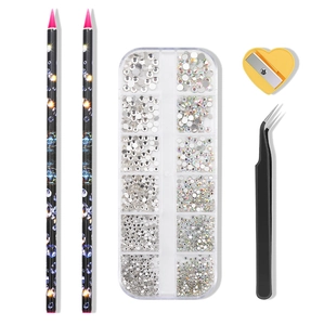 Flat lay of nail art rhinestone kit including wax pens, tweezers, and rhinestones in box