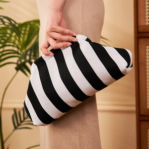 Detail of the black and white striped knitted clutch bag with soft cloud-like folds