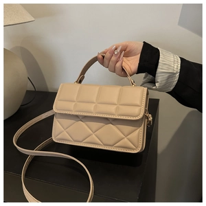Macro view of beige diamond quilted PU leather handbag with detachable shoulder strap