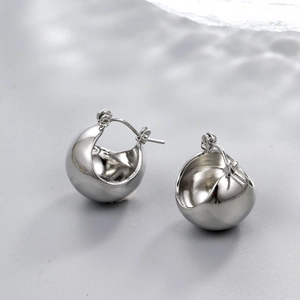 Macro view of chunky silver teardrop hoop earrings with high-polish mirror finish