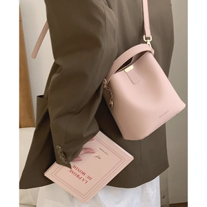 Minimalist pink leather bucket bag for women, crossbody style shown on model