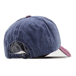 Detail of adjustable metal buckle on vintage washed navy blue and red baseball cap