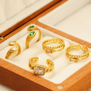 Detailed view of vintage gold zircon rings with intricate textures in a wooden jewelry box