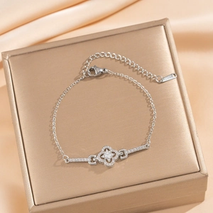 Silver lucky four-leaf clover bracelet with sparkling cubic zirconia on silk background
