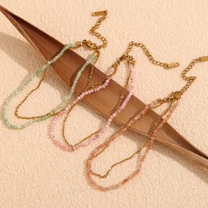 Detail of double-layer 18K gold plated anklets with amazonite beads on palm leaf