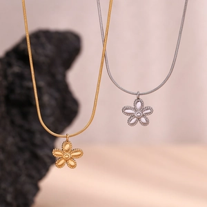 Detailed view of flower pendant necklaces with gold and silver finish on sleek snake chains