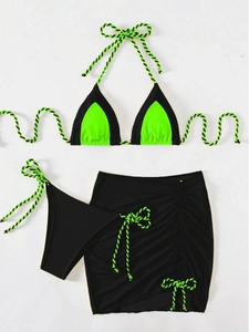 Detail of three-piece contrast bikini set with neon green drawstrings and mini skirt