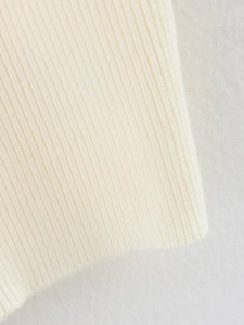 Nahaufnahme von cremeweißem Rippstrick-Gewebe mit weicher Textur und elastischer Webung