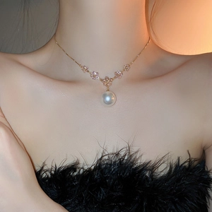 Detail of flower necklace with pink crystals, faux pearls, and golden alloy chain