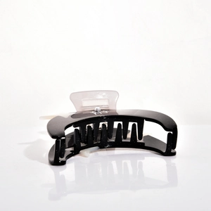 Macro detail of elegant black crescent hair claw with gold sparkles and acrylic accents