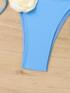 Detail of light blue bikini bottom with high-quality stitching and 3D white rose flower