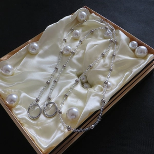Detailed view of clear and silver beaded chain strap inside a gold-trimmed gift box