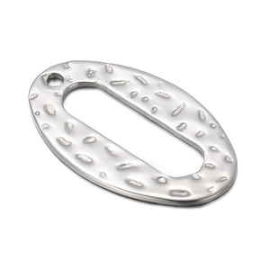 Macro detail of oval stainless steel pendant with hammered texture and single top hole