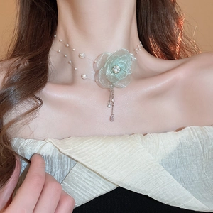 Detail of mint green gauze flower necklace with imitation pearls and rhinestone tassels