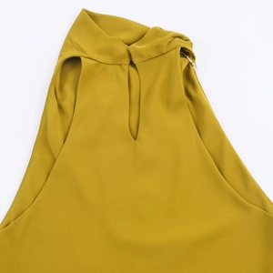 Detail of mustard yellow halter neck top with cut-out collar and sleeveless design