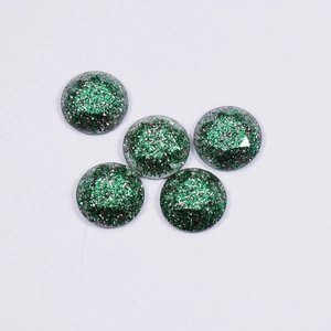 Macro view of five green glitter resin cabochons for DIY jewelry making accessories