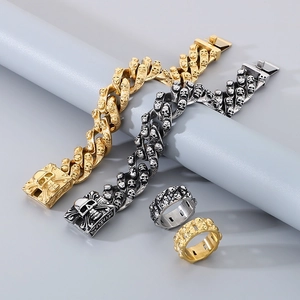 Detail of skull embossed cuban bracelets and matching rings in gold and silver finish