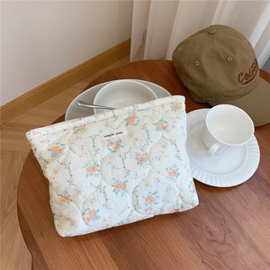 Detailed macro of the orange floral quilted cotton makeup bag with a simple wish tag