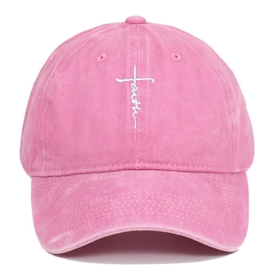 Detaillierte weiße Faith-Kreuz-Stickerei auf einer gewaschenen rosa Baumwoll-Basecap