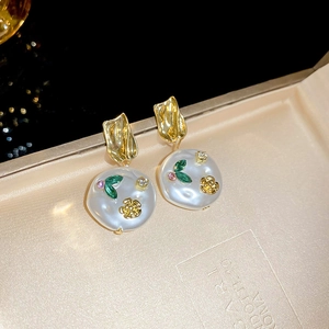 Detail of floral resin earrings with pearls and pink zircons in a jewelry box