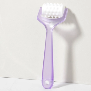 Detail of ergonomic purple handle and white spiked massage roller for head and face therapy