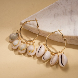 Bohemian gold hoop earrings with cowrie shell charms for a vintage beach aesthetic